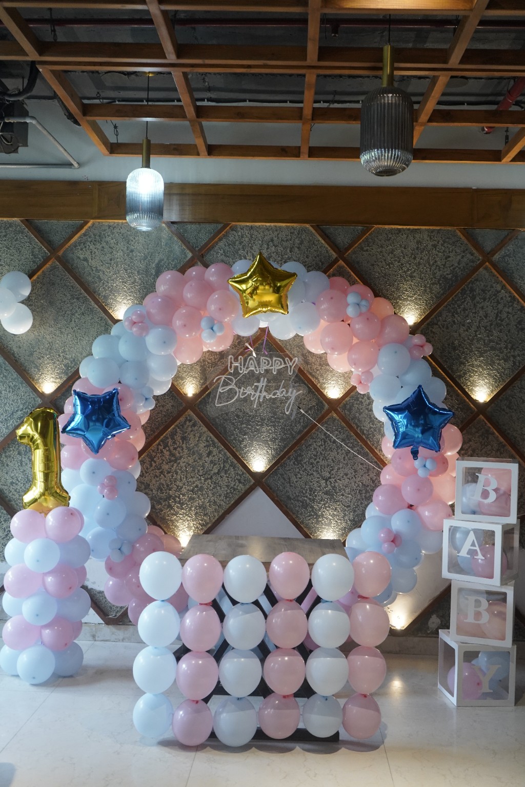 Pastel balloon arch and birthday backdrop created for a first birthday