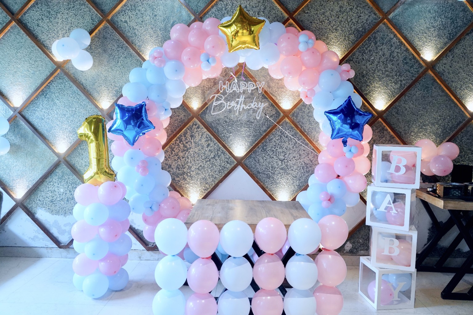 Close-up of the pastel birthday balloon arch and decorated table